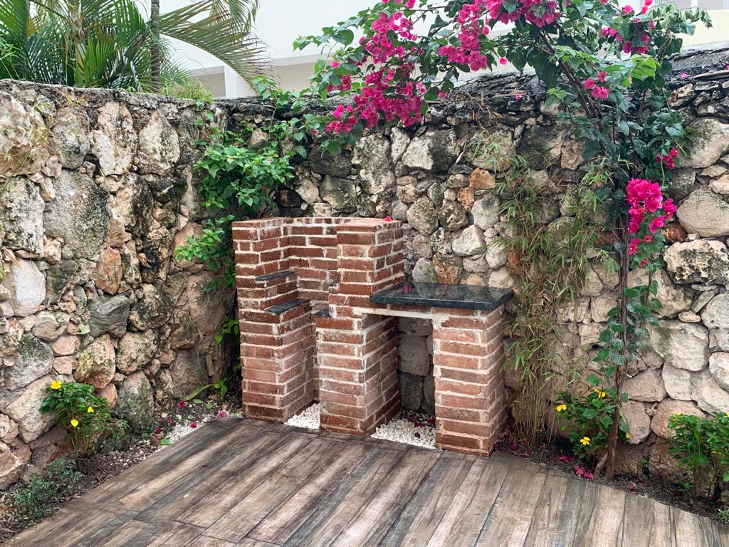Outdoor BBQ grill area with bougainvillea and coral stone wall — villa patio in Punta Cana, Dominican Republic