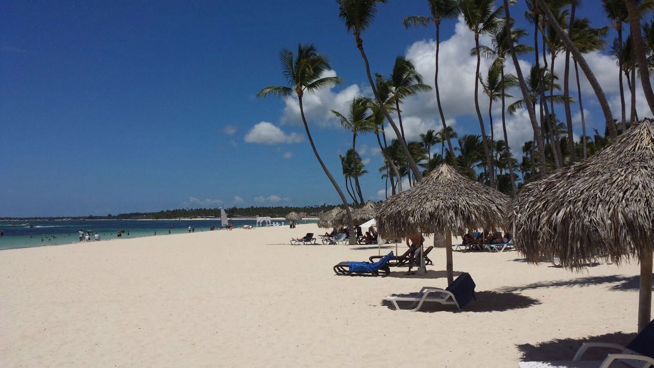 White sand beach with palm trees and palapas — Playa Los Corales near luxury villa for sale in Punta Cana